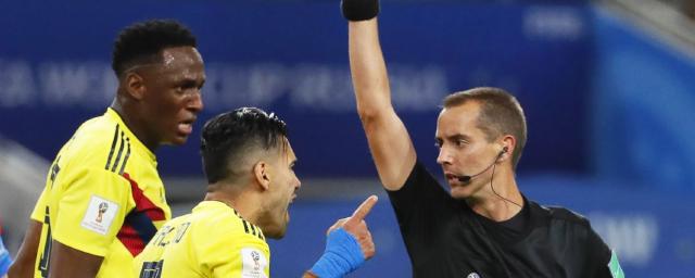 Mark Geiger gives Radamel Falcao (No. 9) of Colombia a yellow card during the World Cup match against England.