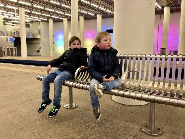 jongens zitten op een bankje in het metrostation van Rotterdam Centraal