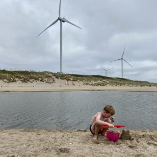 jongen speelt op het strand