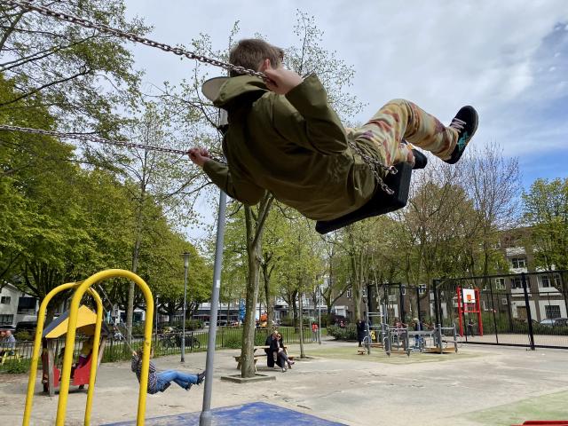 jongen gaat hoog op een schommel