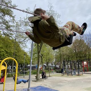jongen gaat hoog op een schommel