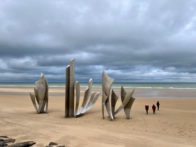 monument op Omaha Beach, onder een (donker)grijze wolkenlucht
