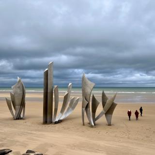 monument op Omaha Beach, onder een (donker)grijze wolkenlucht
