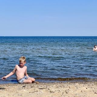 jongen speelt op het strand