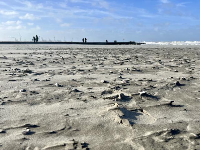 mensen wandelen op de pier naast het strand