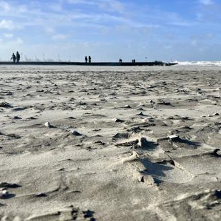 mensen wandelen op de pier naast het strand